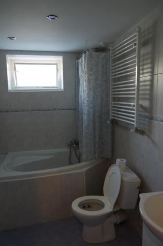 a bathroom with a toilet and a tub and a sink at Apartment Cajakova in Košice