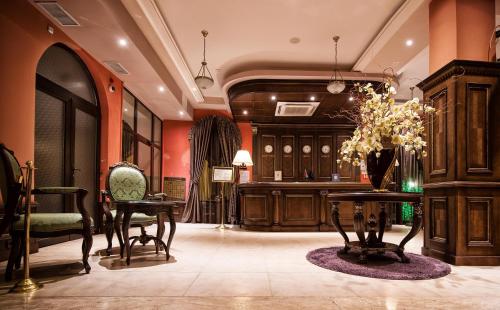 a living room filled with furniture and a large clock at Hotel Chinar in Hisarya