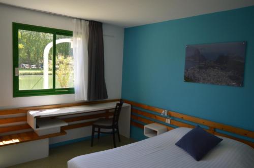 a room with two beds and a desk and a window at N'Atura Hôtel in Aire-sur-lʼAdour