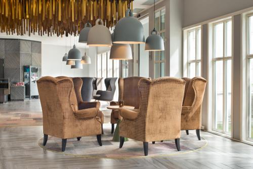 a lobby with wicker chairs and pendant lights at Quality Hotel Skjærgården in Langesund