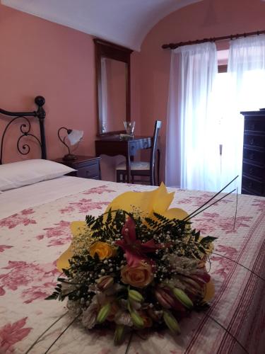 a bouquet of flowers on a bed in a bedroom at La Casa dei Nonni B&B in Scanno