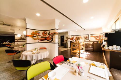 a restaurant with colorful chairs and tables in a room at Hôtel Hélios in Juan-les-Pins