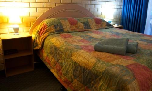 a bedroom with a bed with a colorful comforter at Esperance Beachfront Resort in Esperance