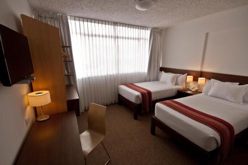 普諾的住宿－蒂拉維瓦普諾廣場酒店，一间酒店客房,设有两张床和电视