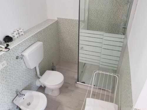 a bathroom with a toilet and a glass shower at Desiderio Monolocali e camere in Lido Adriano