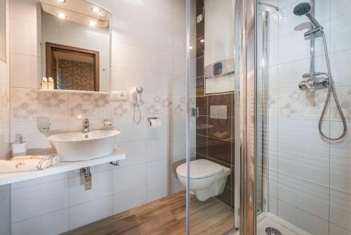 La salle de bains est pourvue d'une douche, d'un lavabo et de toilettes. dans l'établissement Apartmánový Dom Kriváň, à Bešeňová