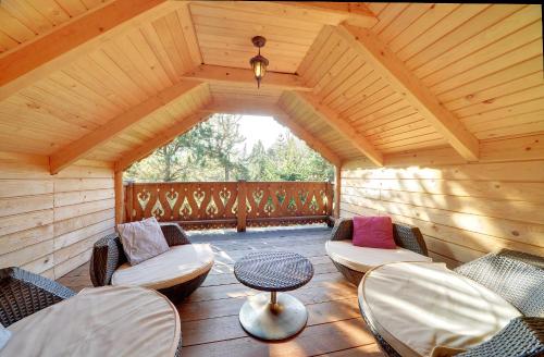 un ampio portico in legno con sedie e tavolo di Sun Seasons 24 - Domek Bacówka a Wisła