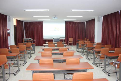 a classroom with desks and chairs and a projector at 보성녹차리조트 in Boseong