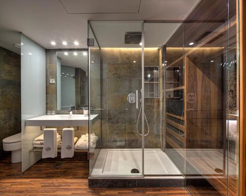 uma casa de banho com um chuveiro e um lavatório. em Hotel Gran Derby Suites, a Small Luxury Hotel of the World em Barcelona