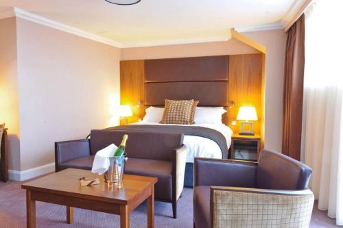 a hotel room with a bed and two chairs and a table at Rox Hotel Aberdeen by Compass Hospitality in Aberdeen