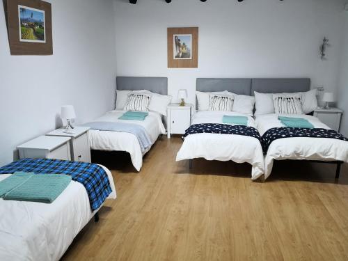 three beds in a room with wooden floors at Varanski Vista in San Miguel de Abona