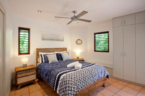 a bedroom with a bed and a ceiling fan at L'Auberge Noosa in Noosa Heads