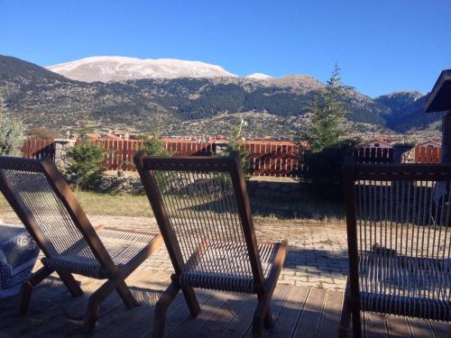 two chairs sitting on a porch with mountains in the background at Parnassos Ski Chalet in Arachova