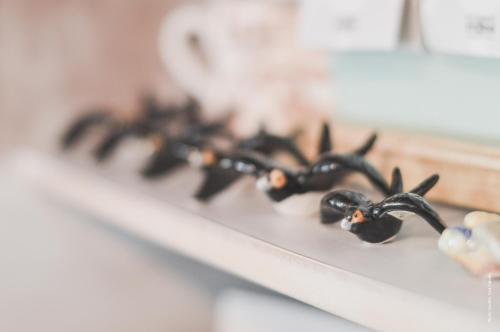 a row of black spiders sitting on a shelf at Luz Charming Houses in Fátima