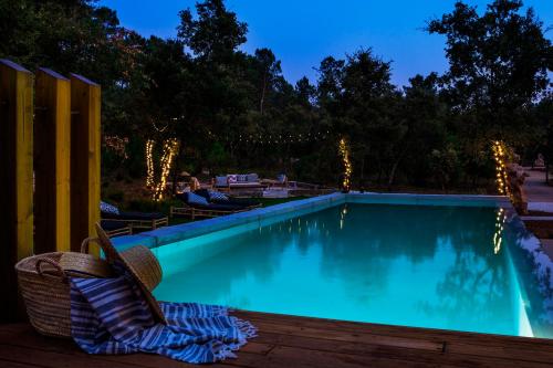 a swimming pool at night with a chair next to it at Luz Charming Houses in Fátima