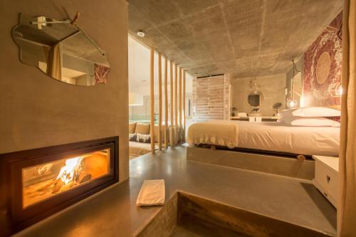 a bedroom with a fireplace next to a bed at Luz Charming Houses in Fátima