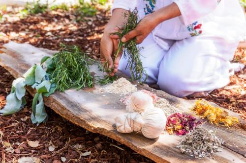 a woman sitting on a wooden cutting board with a doll at Luz Charming Houses in Fátima