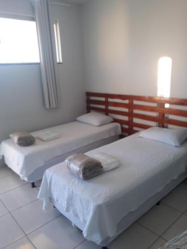 a room with two beds and a window at Flats Di Cavalcanti in Uberlândia