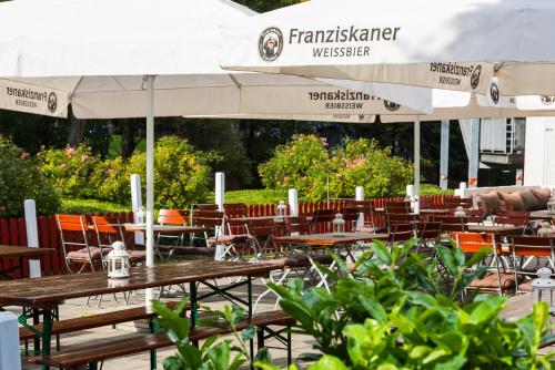 an outdoor restaurant with tables and chairs and umbrellas at Hotel Oberhausen Neue Mitte affiliated by Meliá in Oberhausen