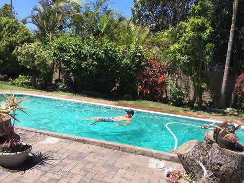 Un hombre está nadando en una piscina en Log Inn, en East London