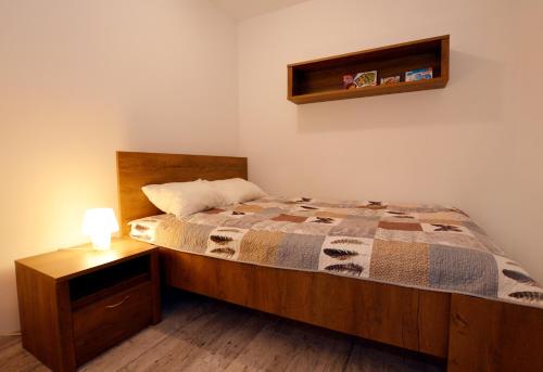 コウォブジェクにあるApartament przy Latarni Morskiejのベッドルーム1室(ベッド1台、ナイトスタンドのランプ付)