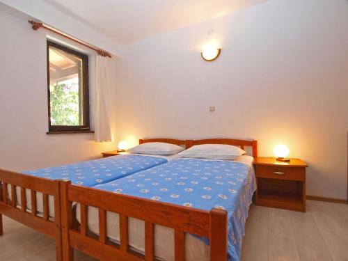 ein Schlafzimmer mit einem Bett, zwei Nachttischen und einem Fenster in der Unterkunft Apartment Elda 1455 in Fažana