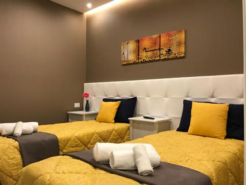 グラヴィーナ・イン・プーリアにあるMy Homeの黄色いシーツが備わるベッド2台付きの部屋