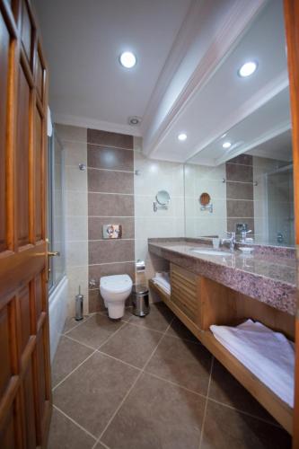 a bathroom with a sink and a toilet in it at Hotel Greenland - All Inclusive in Oludeniz