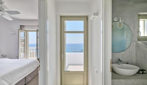 a bedroom with a bathroom with a tub and a sink at Tourlos Bay Villas Mykonos in Tourlos