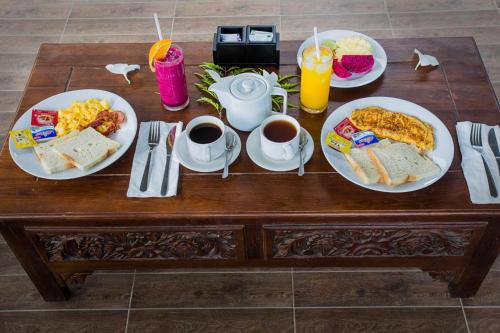 a table with two plates of breakfast foods and drinks at 221 Garden Cottages in Nusa Lembongan