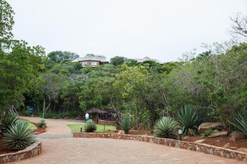 a garden with a house on top of a hill at Blyde Canyon, A Forever Resort in Matibidi