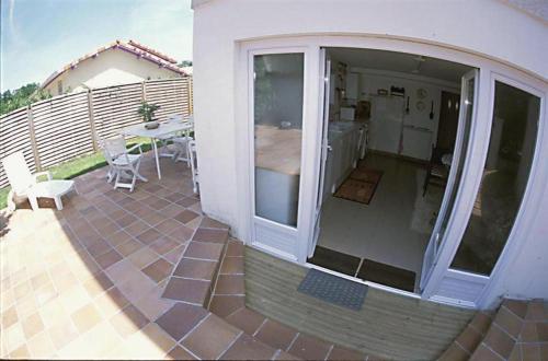 a patio with a sliding glass door and a table at L'Hernani in Capbreton