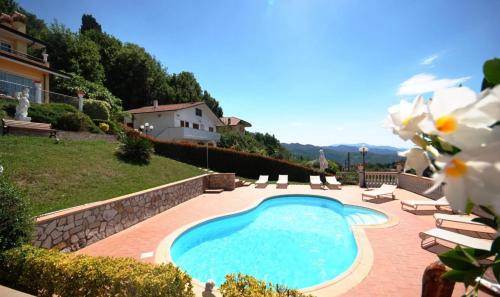 Corsanico-BargecchiaにあるVilla Sophiaの椅子と家のある庭のスイミングプール