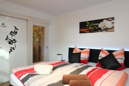 a bedroom with a large bed with colorful pillows at Ferienwohnung Kopp II in Greiz