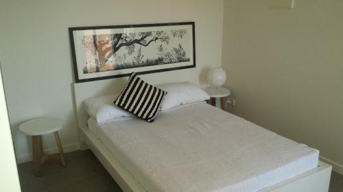 a small bedroom with a bed with a picture on the wall at Onslow Apartments in Onslow
