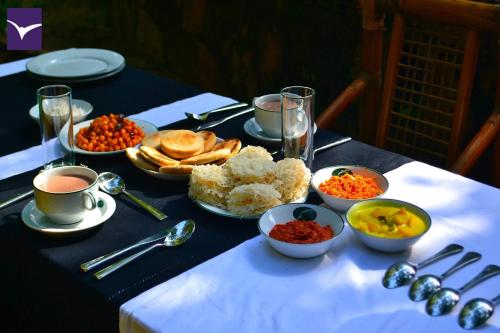 a table topped with plates and bowls of food at Clio Ella Adventure in Ella