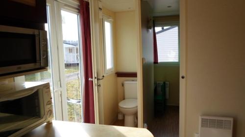 ein kleines Bad mit einem WC und einem Fenster in der Unterkunft Camping les Pinasses in La Chapelle