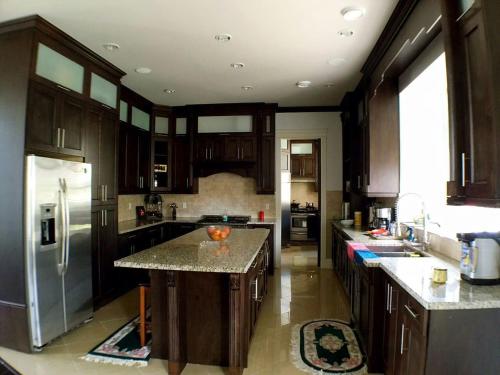 a kitchen with wooden cabinets and a stainless steel refrigerator at Sunny Island by White Rock in White Rock