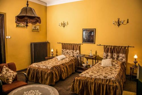 una habitación de hotel con 2 camas y una silla en Pałac Baborówko, en Szamotuły