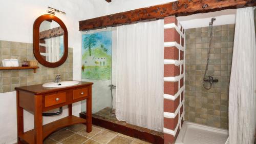 Un baño con lavabo y ducha con cortina de ducha. en Finca Lucía - La Lava, en Mácher