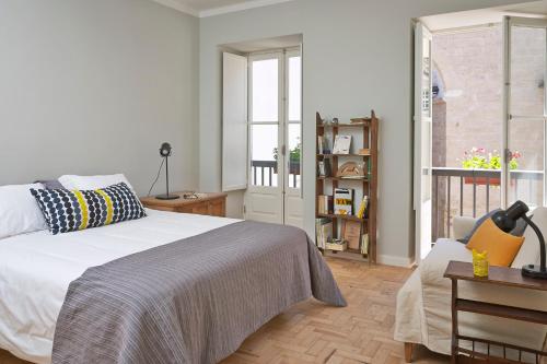 sypialnia z białym łóżkiem i oknem w obiekcie Casas do Arco w mieście Coimbra