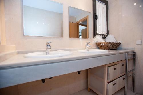 Baño con 2 lavabos y espejo en Apartamento San Bernardo, en Sevilla