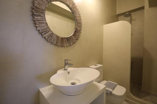a bathroom with a white sink and a mirror at Eos Villa in Imerovigli