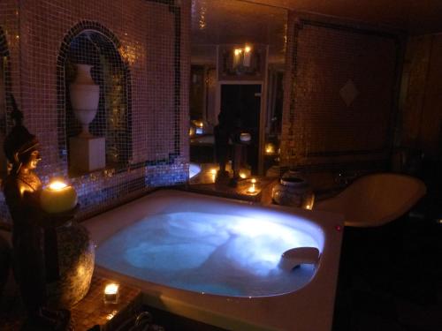 une grande baignoire dans une chambre avec bougies dans l'établissement Mas de la Chapelle, à Arles