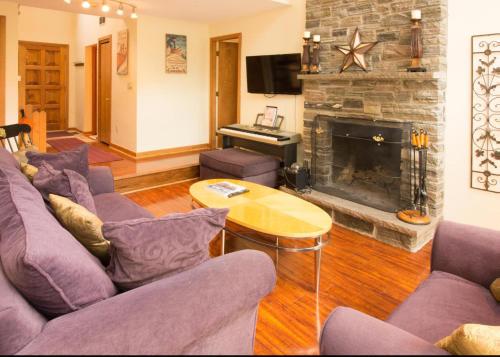 a living room with purple couches and a fireplace at Lake Winnipesaukee230 in Mallard Cove