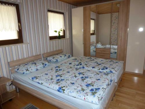 NohraにあるFerienwohnung Jakobのベッドルーム1室(青い花のベッド1台付)