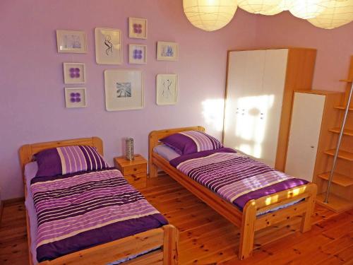 two beds in a room with purple walls at Im Sternhaus Waren Müritz in Waren