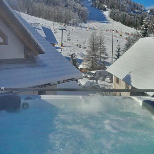 a hot tub with snow on the side of a ski slope at House Neza in Kranjska Gora