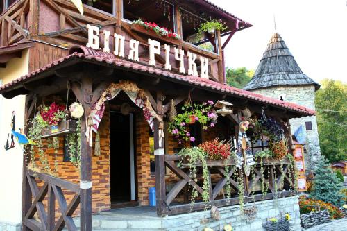a building with a sign that reads butrint at Bilya Richky Hotel in Kamianets-Podilskyi