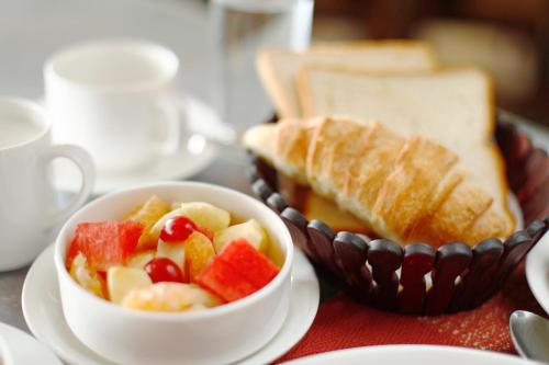 a bowl of fruit and a bowl of bread at United Business Hotel in Kathmandu